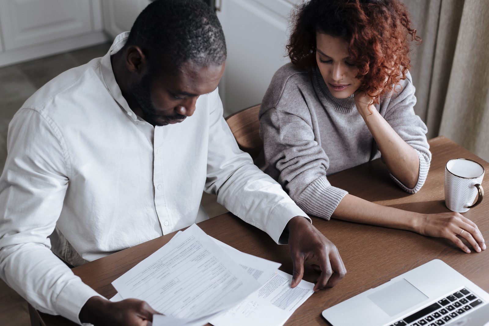 A couple reviewing mortgage paperwork together at their kitchen table